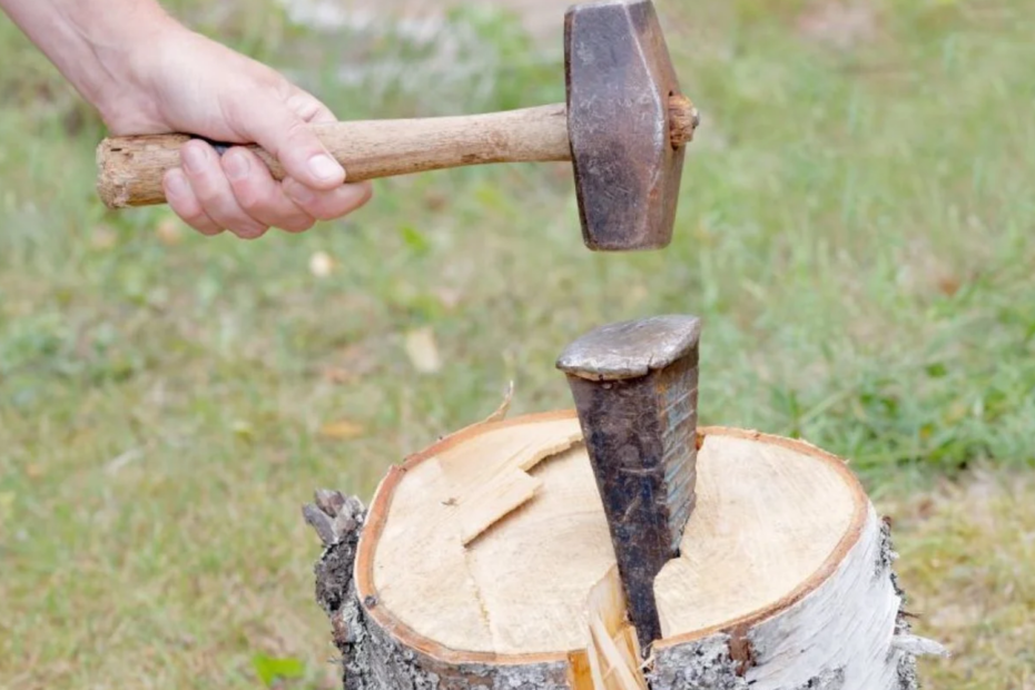 Splitting wood with wedge and hammer